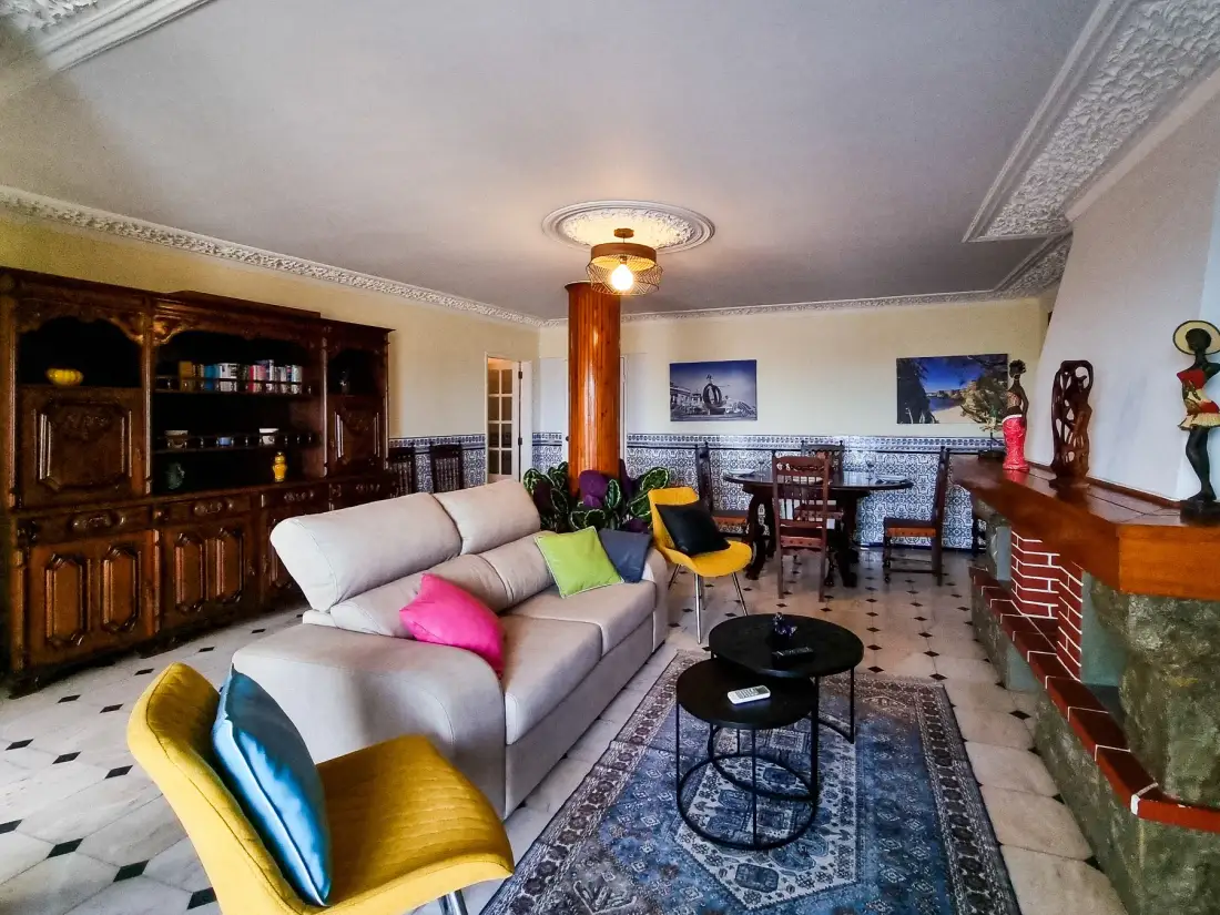 Una sala amueblada con asientos, una mesa de comedor y una chimenea de ladrillo.