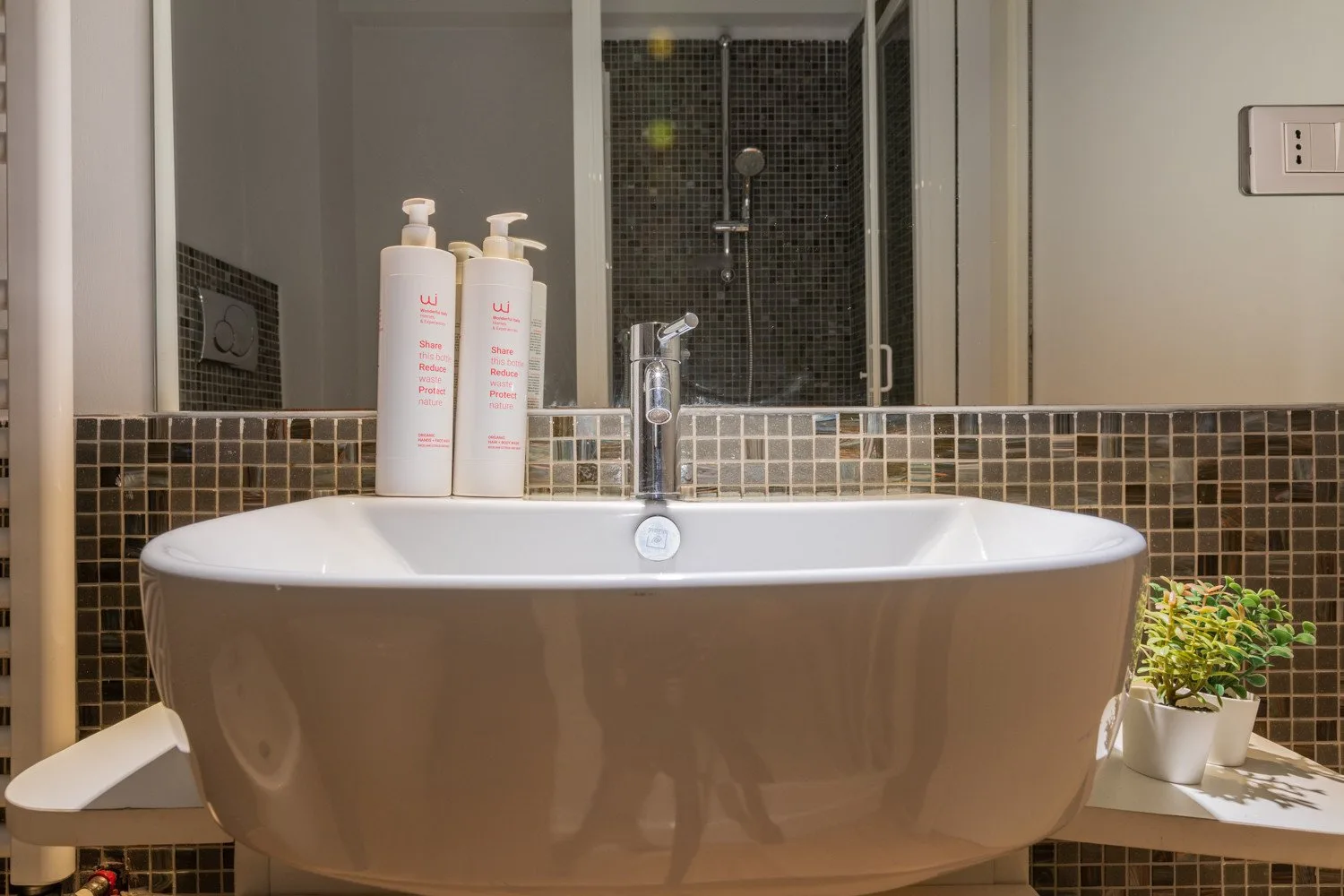 A bathroom with a freestanding bathtub, tiled backsplash, and sink faucet.