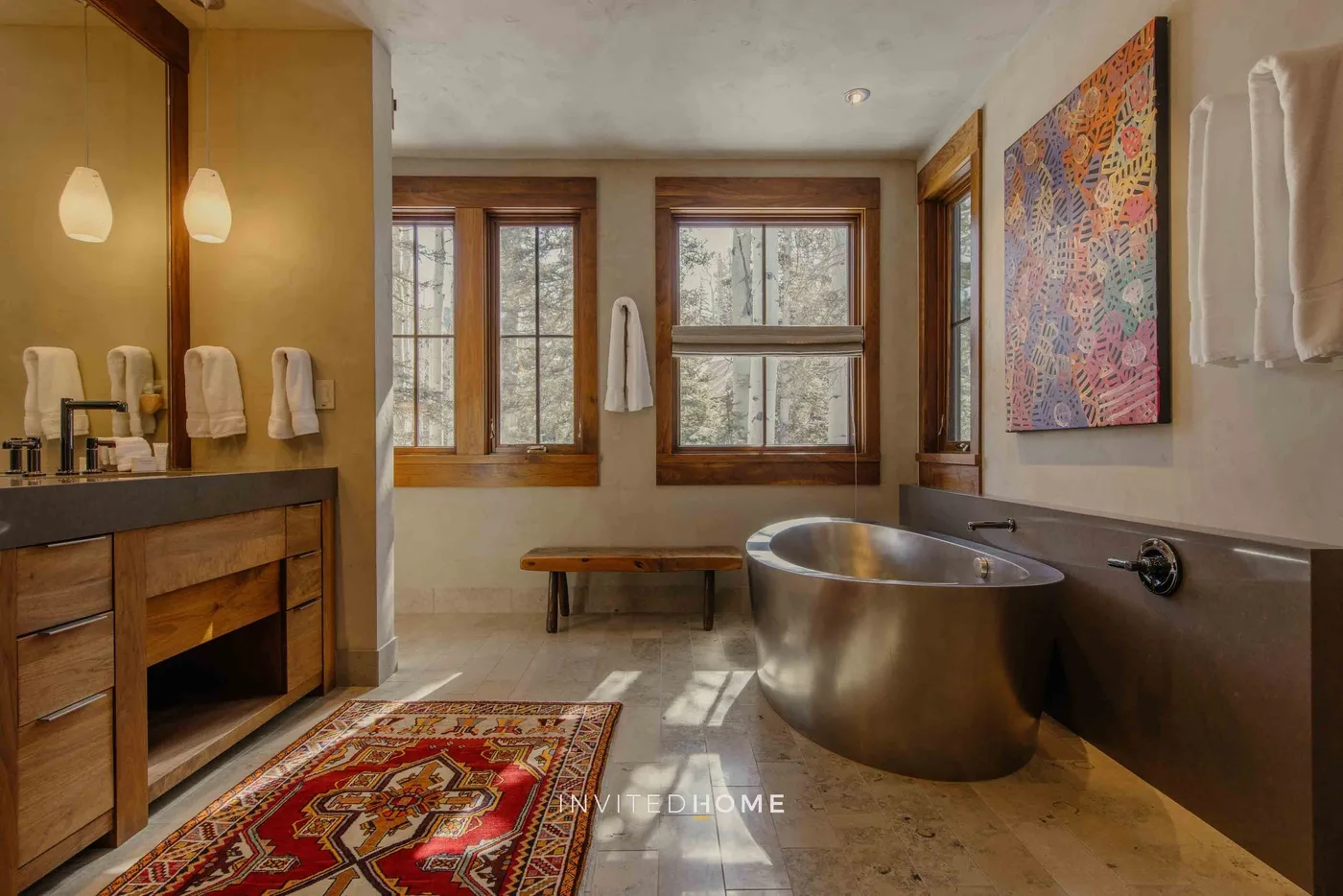 A bathroom with a freestanding tub, vanity, and windows.