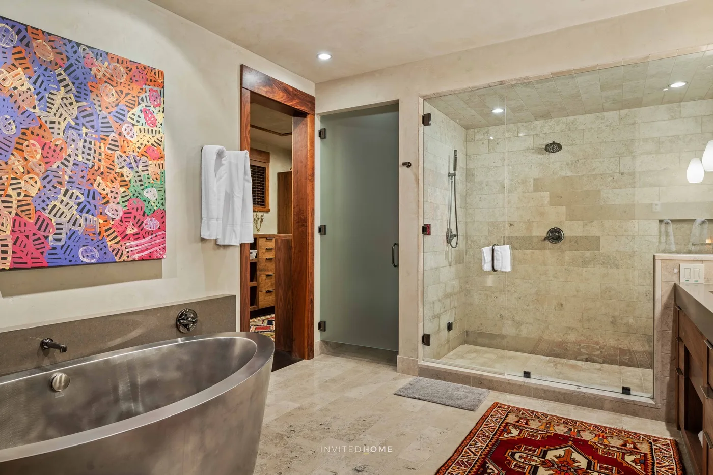 A bathroom with a glass-enclosed shower and a large soaking tub.