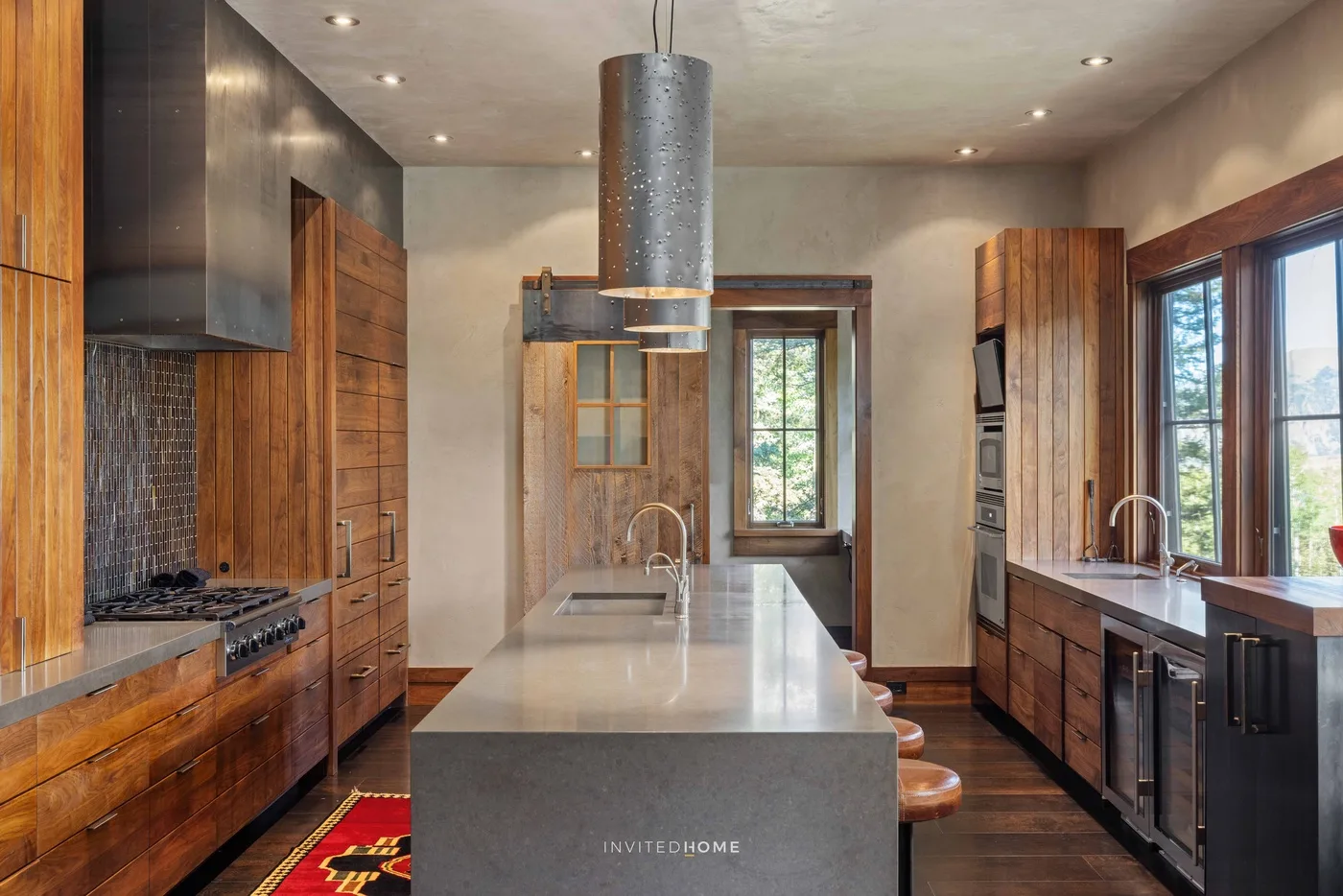 A modern kitchen with wooden cabinetry, a central island, and large windows.