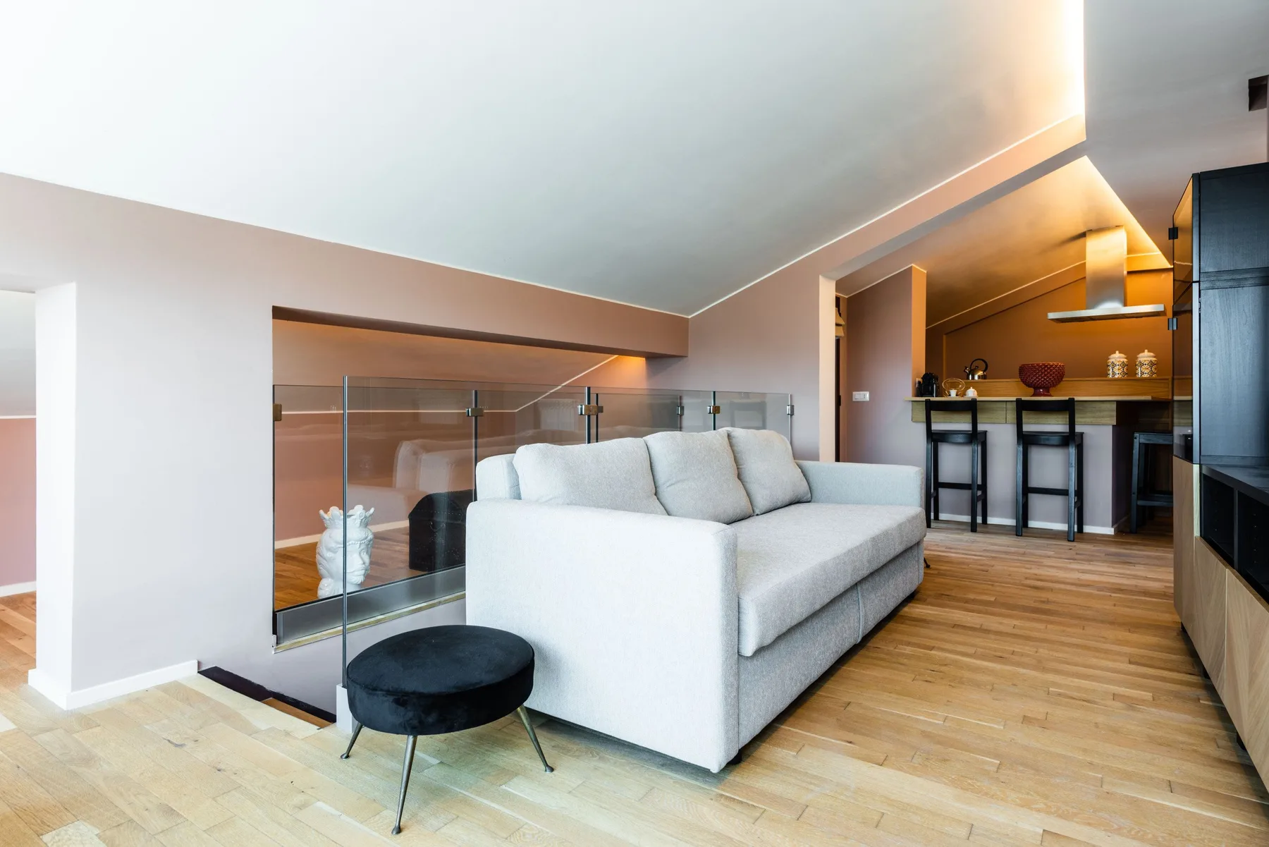 A living room with a light-colored sofa and a dining counter in the background.