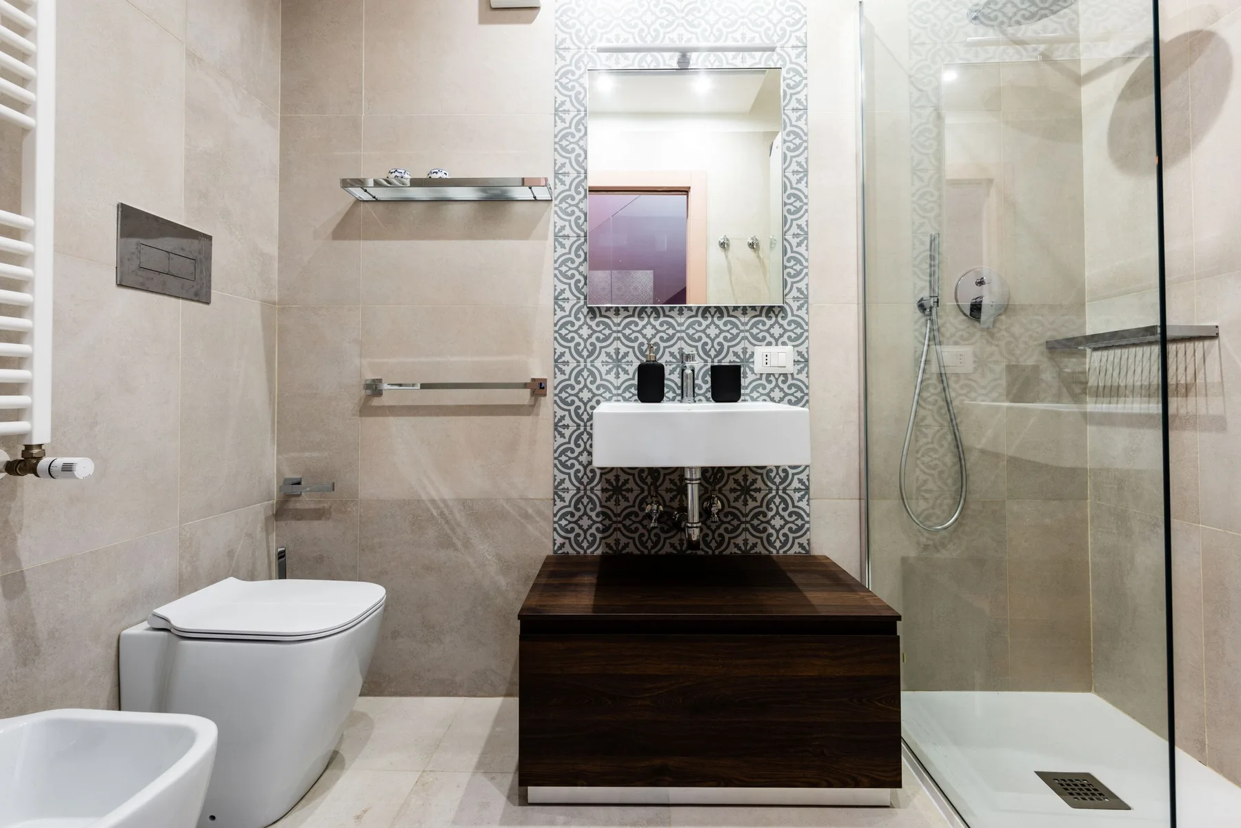 A modern bathroom with a sink, toilet, and glass shower.