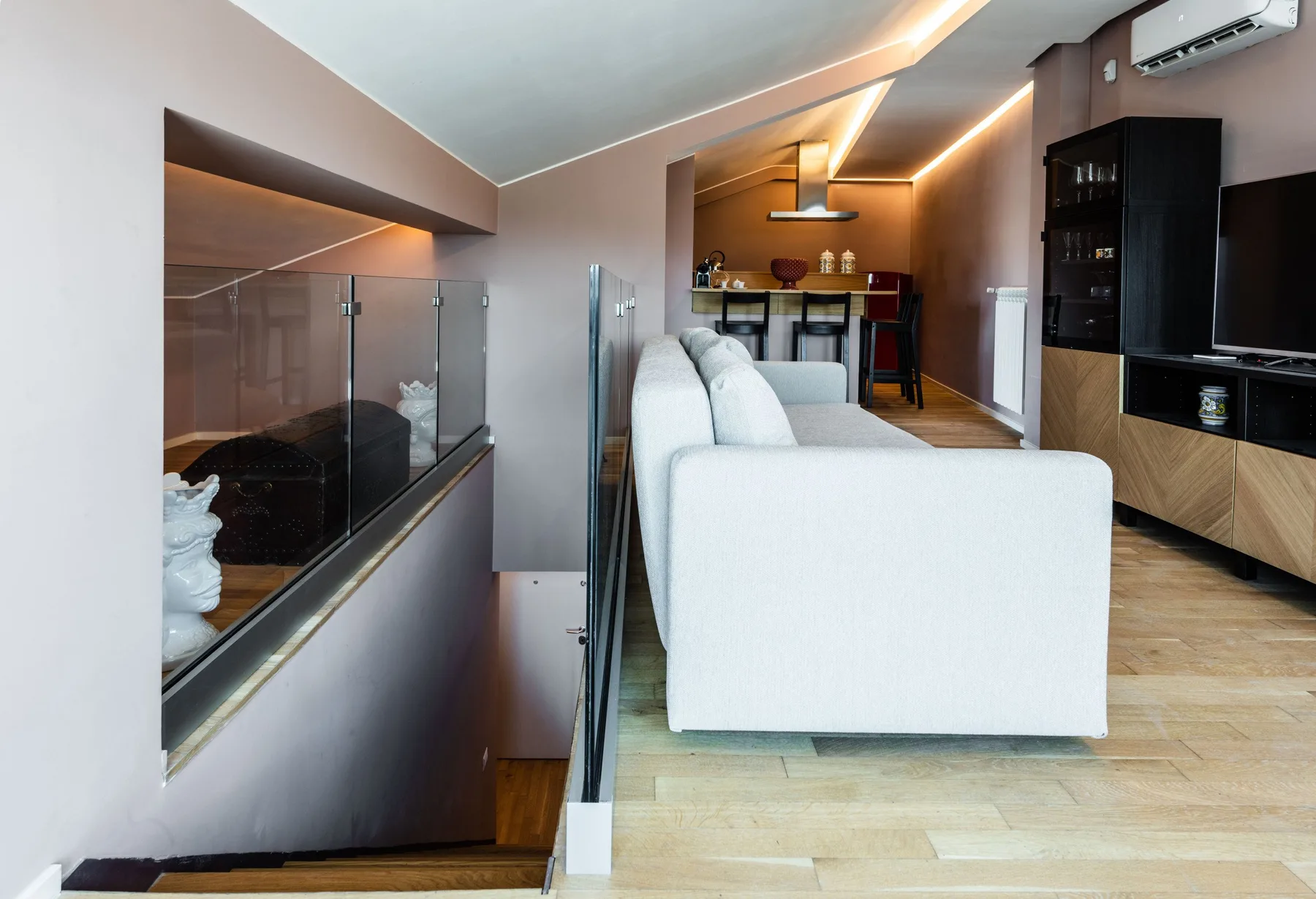 A modern living room with white seating, a glass-sided fireplace, and a dining area.
