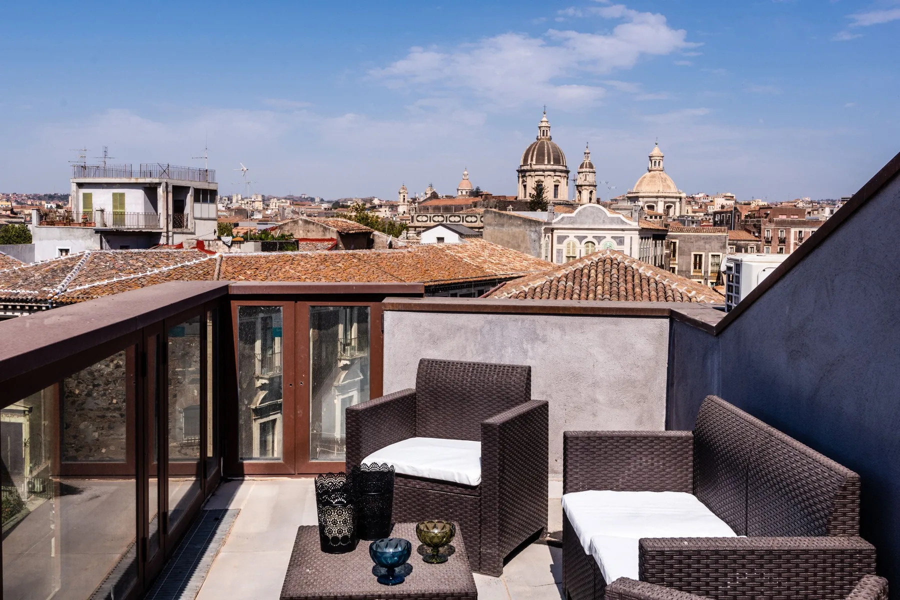 Una terraza en la azotea con asientos al aire libre ofrece vistas del perfil urbano y edificios con cúpulas.