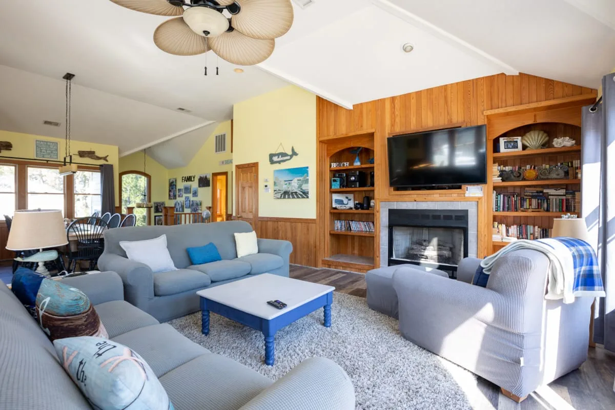 A living room with seating around a coffee table and a fireplace.