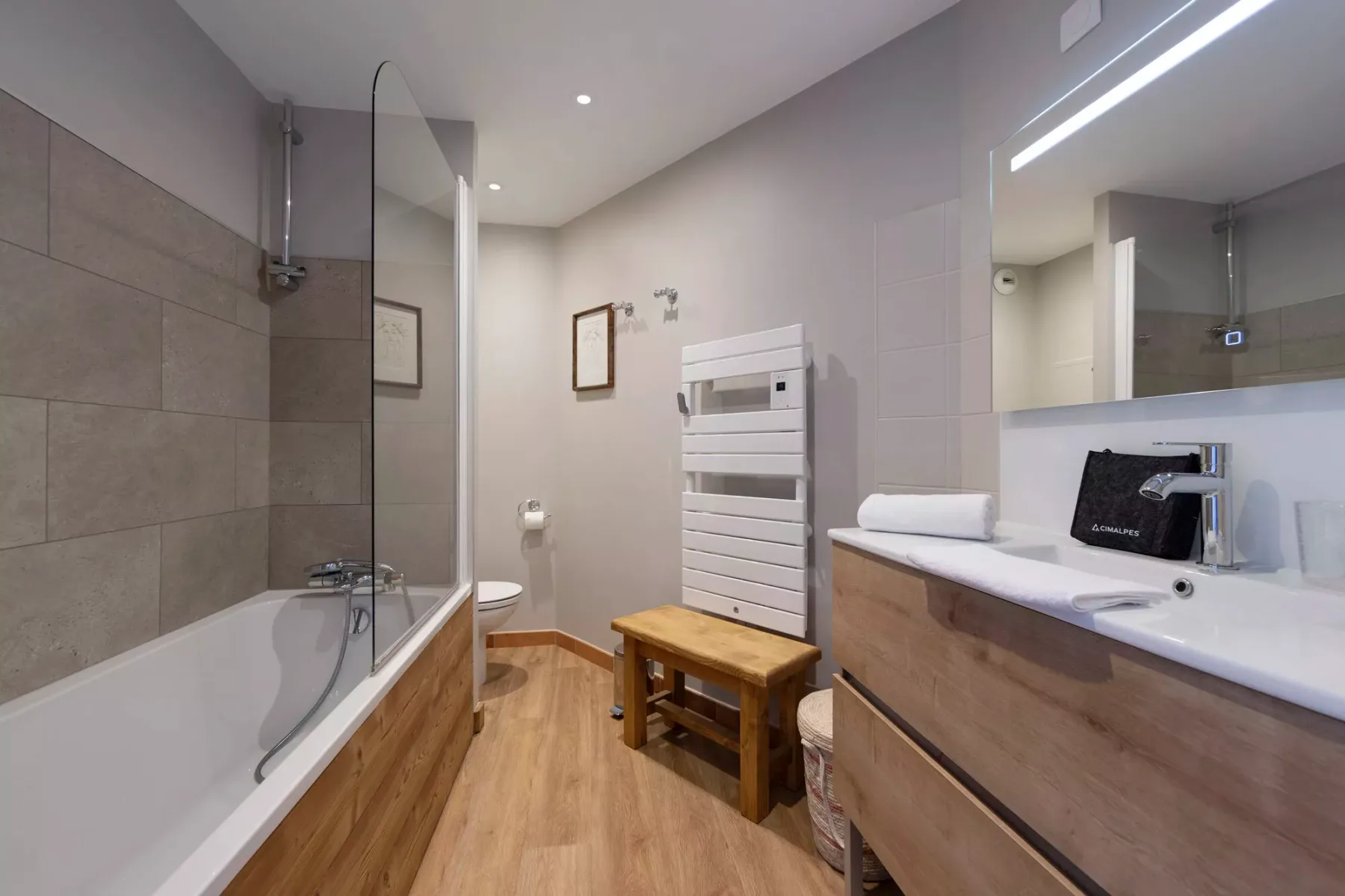 Un baño con bañera, lavabo y mueble de madera.