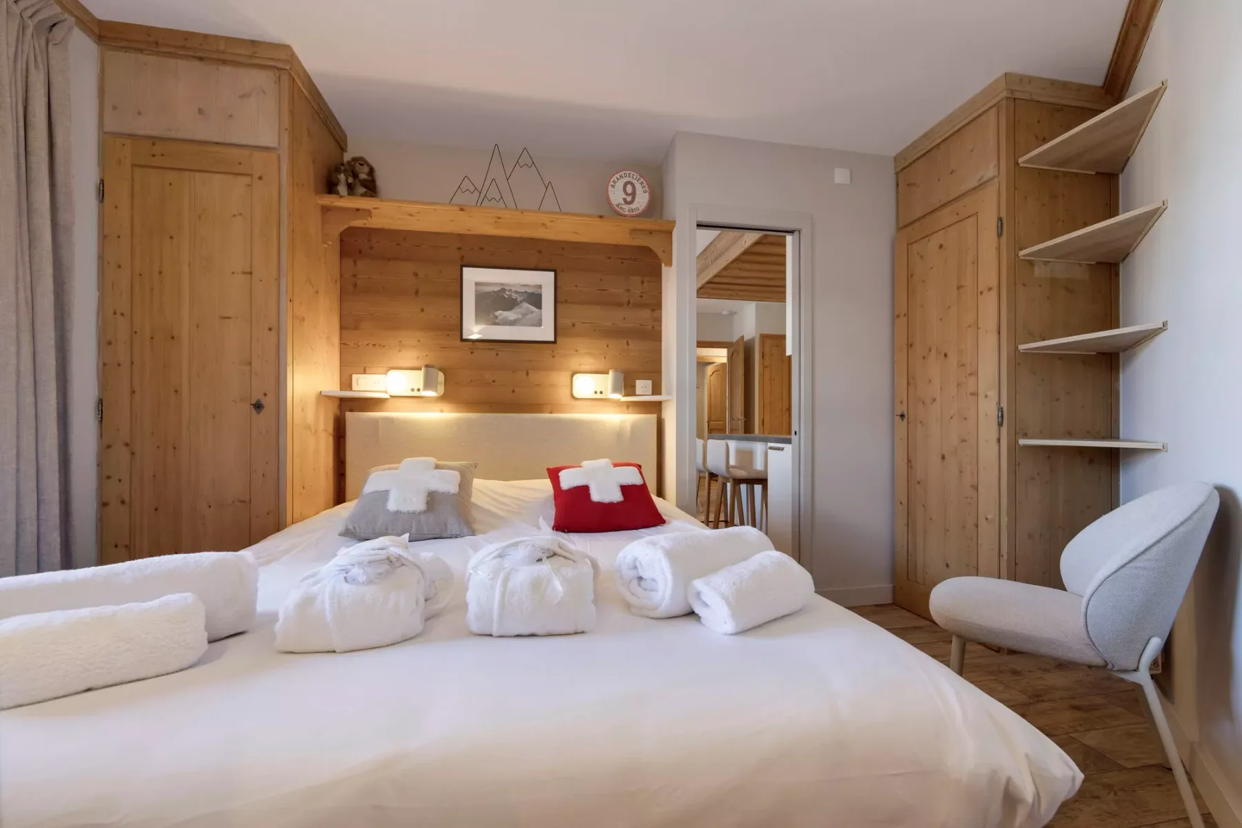 Un dormitorio con una cama grande, armarios de madera y estantes abiertos.