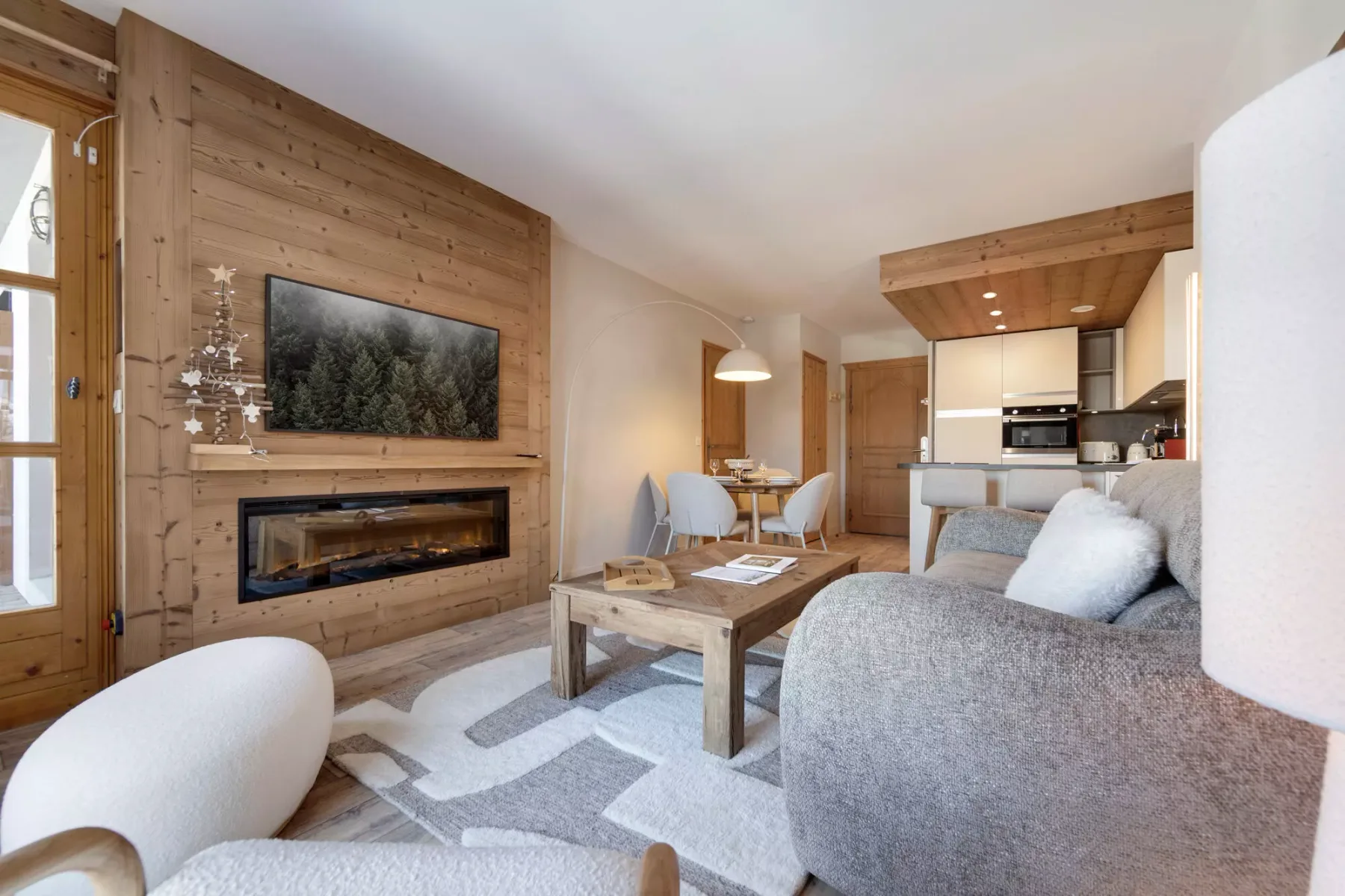 Una sala luminosa con una pared revestida de madera, chimenea y zona de estar.