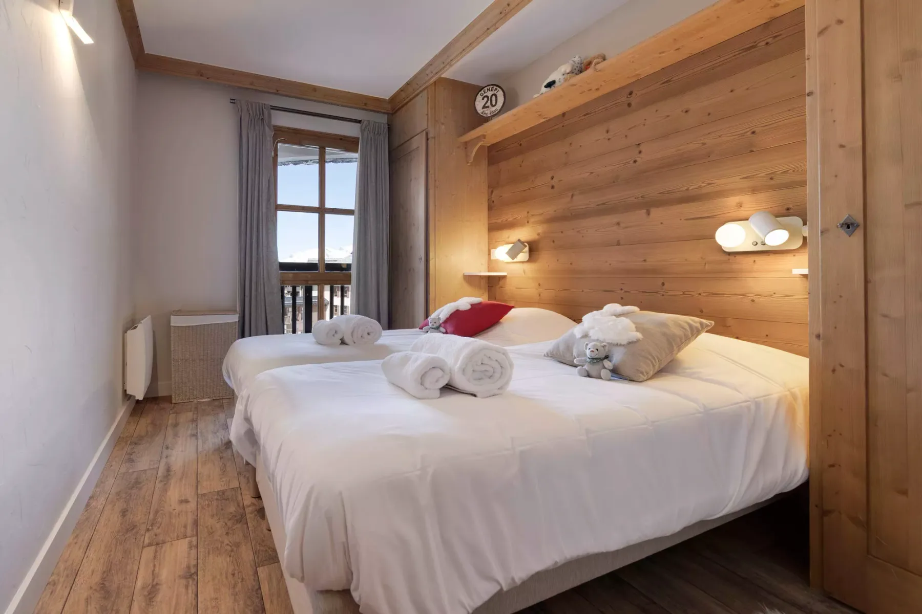 Un dormitorio con una cama grande, una pared revestida de madera y una ventana.
