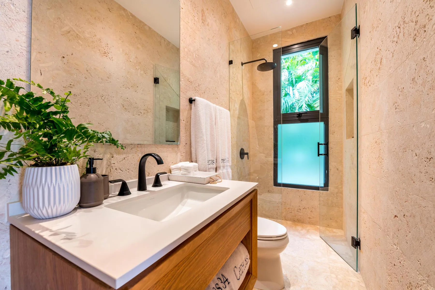 Un baño con lavabo, espejo y ducha de cristal.