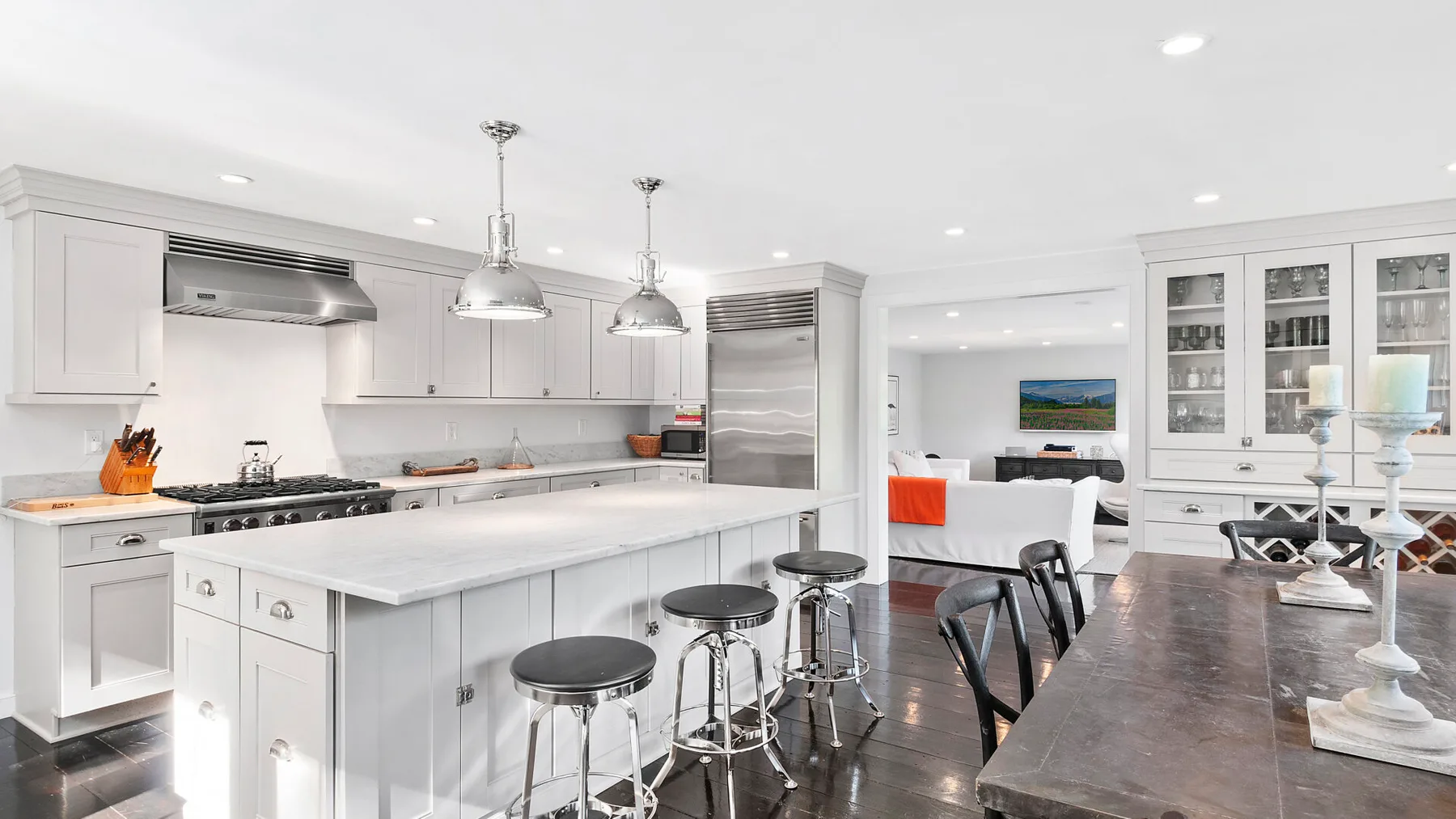 Una cocina luminosa con una isla grande y una mesa de comedor en primer plano.