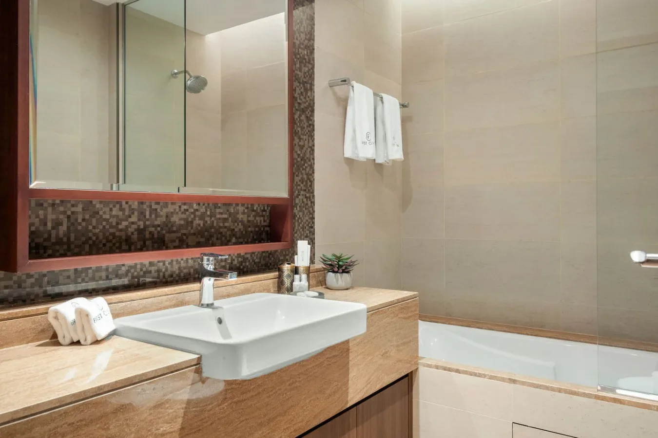 A bathroom with a sink, countertop, and bathtub.