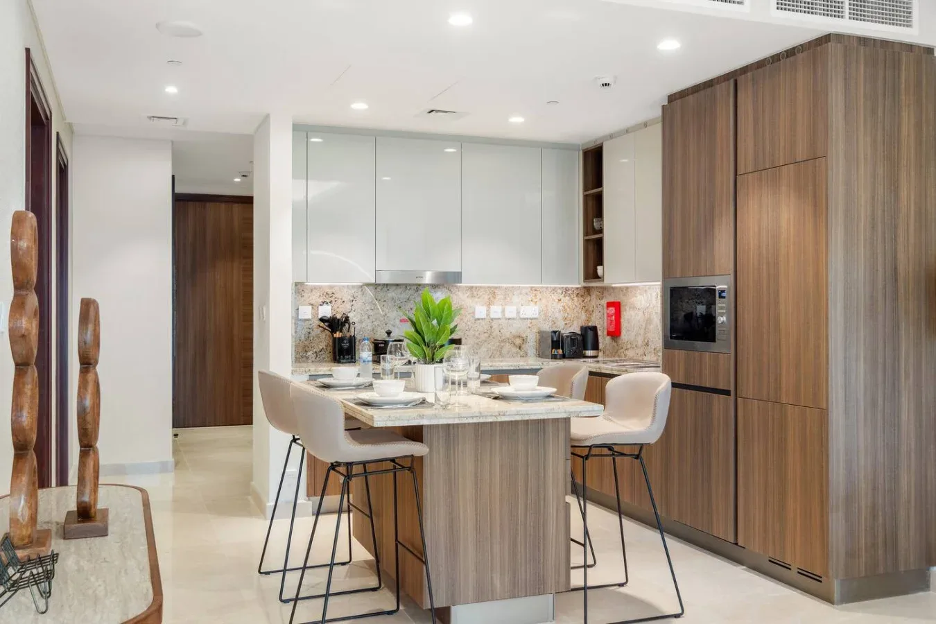 A bright modern kitchen with a central island and dining seating.