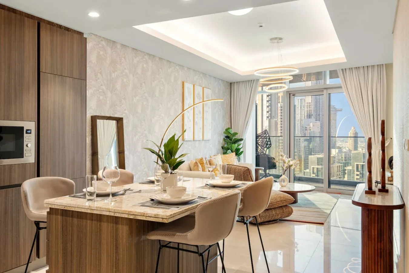 A modern dining area opens into a bright living space with large windows.