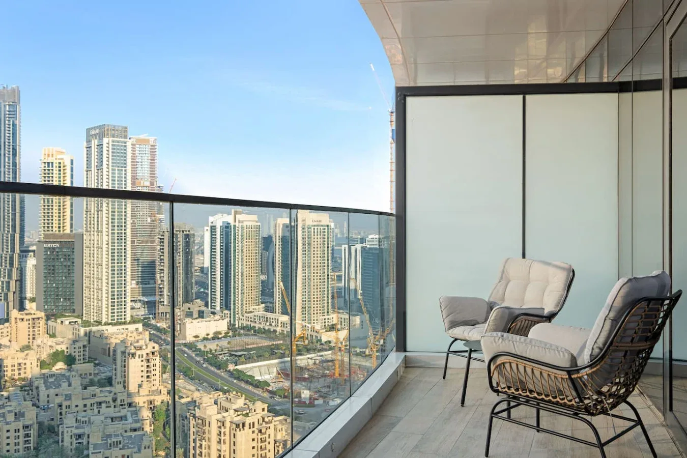 A balcony seating area overlooks a cluster of city high-rises.