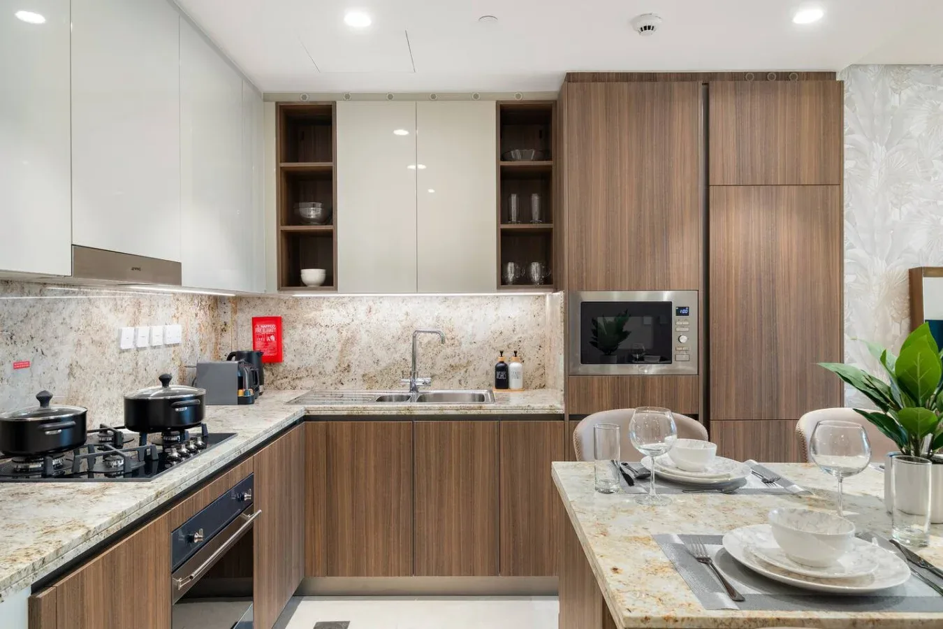 A modern kitchen with wood cabinetry, a cooking area, and a dining table.