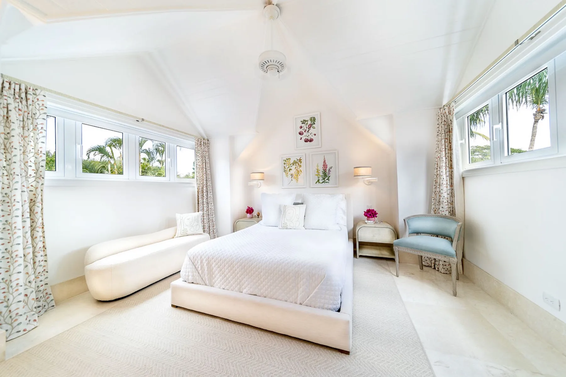 Un dormitorio luminoso con una cama, una chaise longue y una ventana.