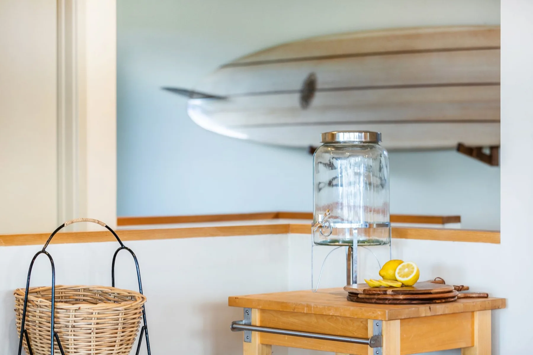Un pequeño comedor con una mesa de madera y un dispensador de agua de vidrio.