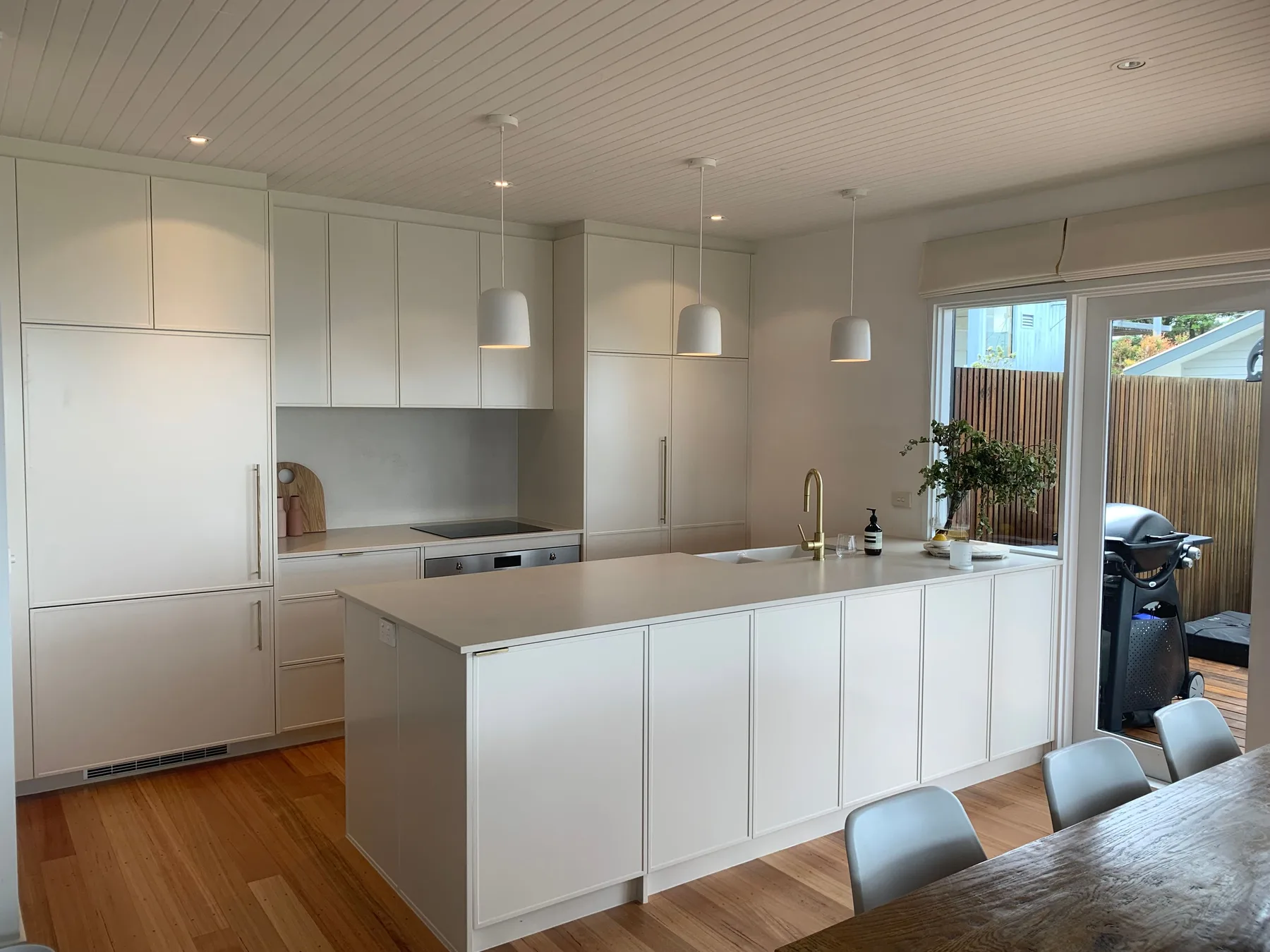 Una cocina luminosa con una isla grande y una mesa de comedor.