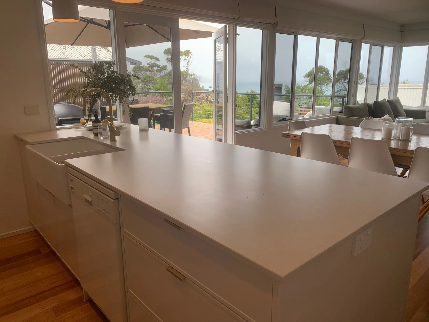 Una cocina luminosa con una gran isla se abre a un comedor y un patio.