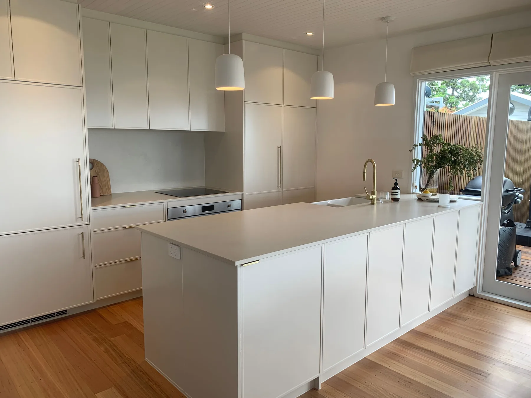 Una cocina moderna y luminosa con armarios blancos y una isla central.
