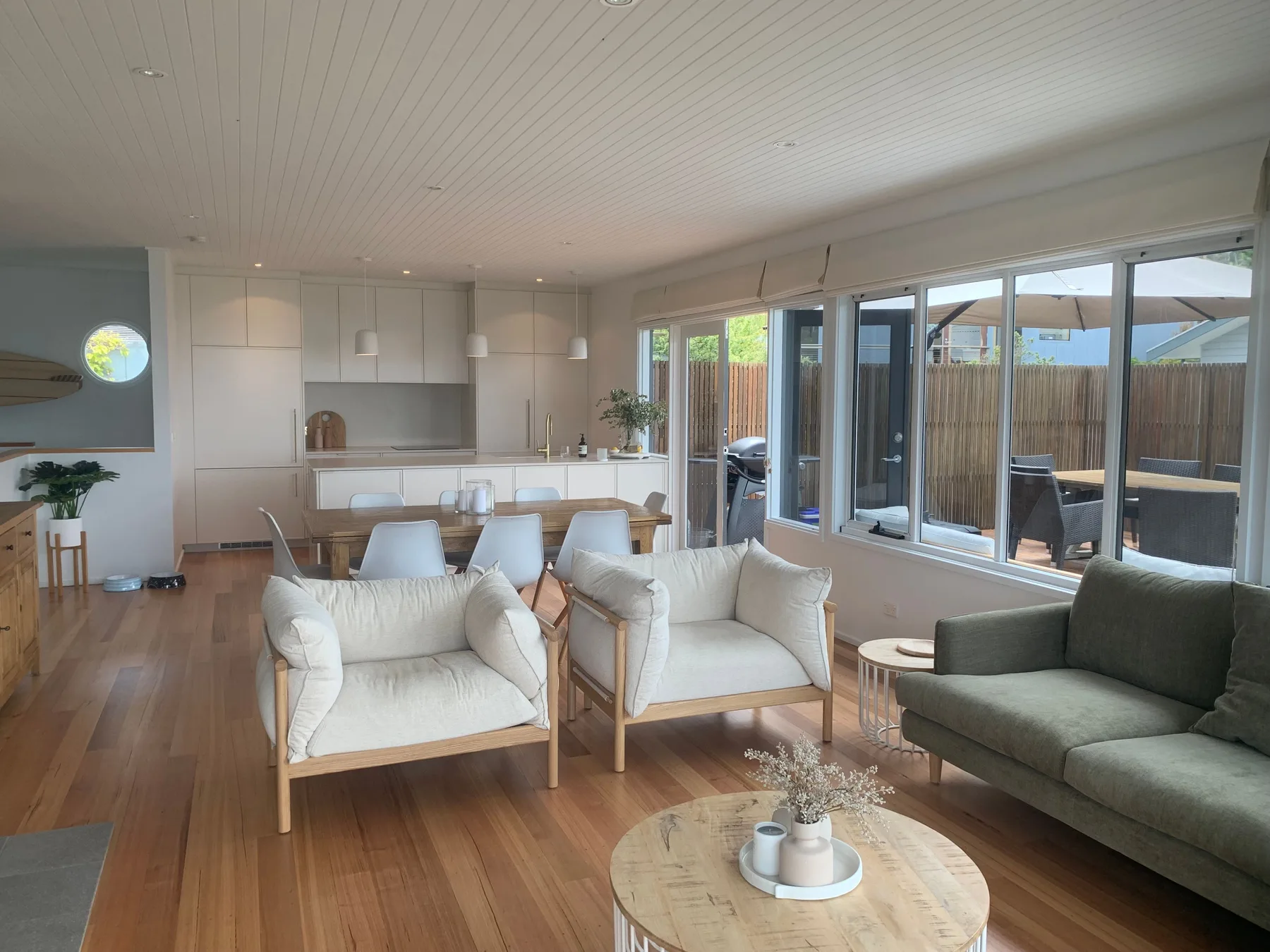 Una sala luminosa con asientos junto a grandes ventanas que dan a un patio cercado.