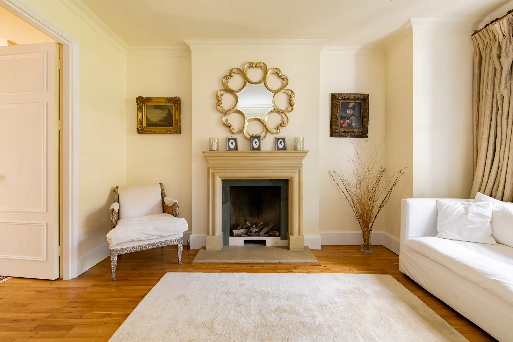 Una sala luminosa con chimenea, asientos y una alfombra.