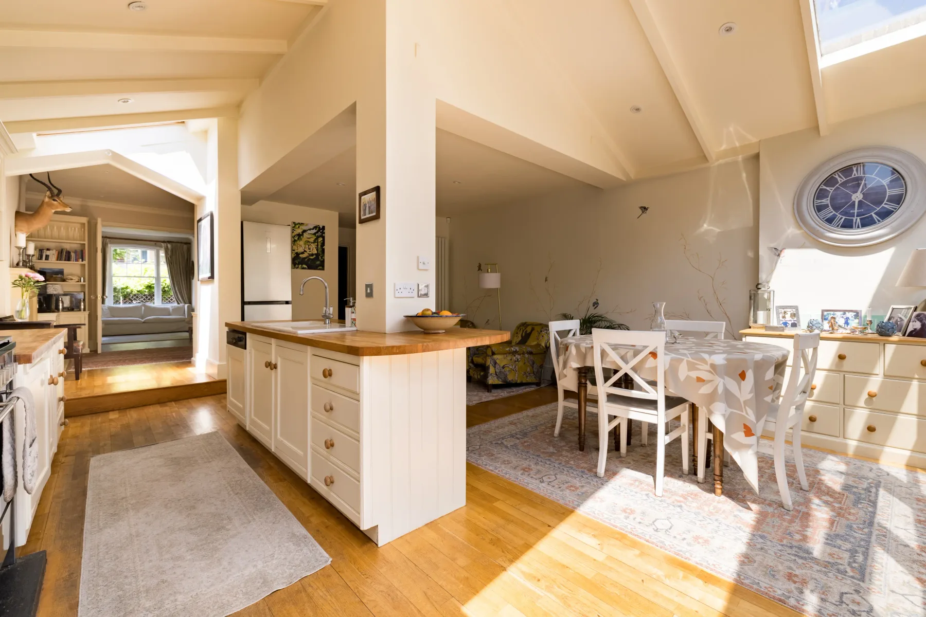 Una luminosa cocina-comedor de planta abierta con una isla central y una mesa.