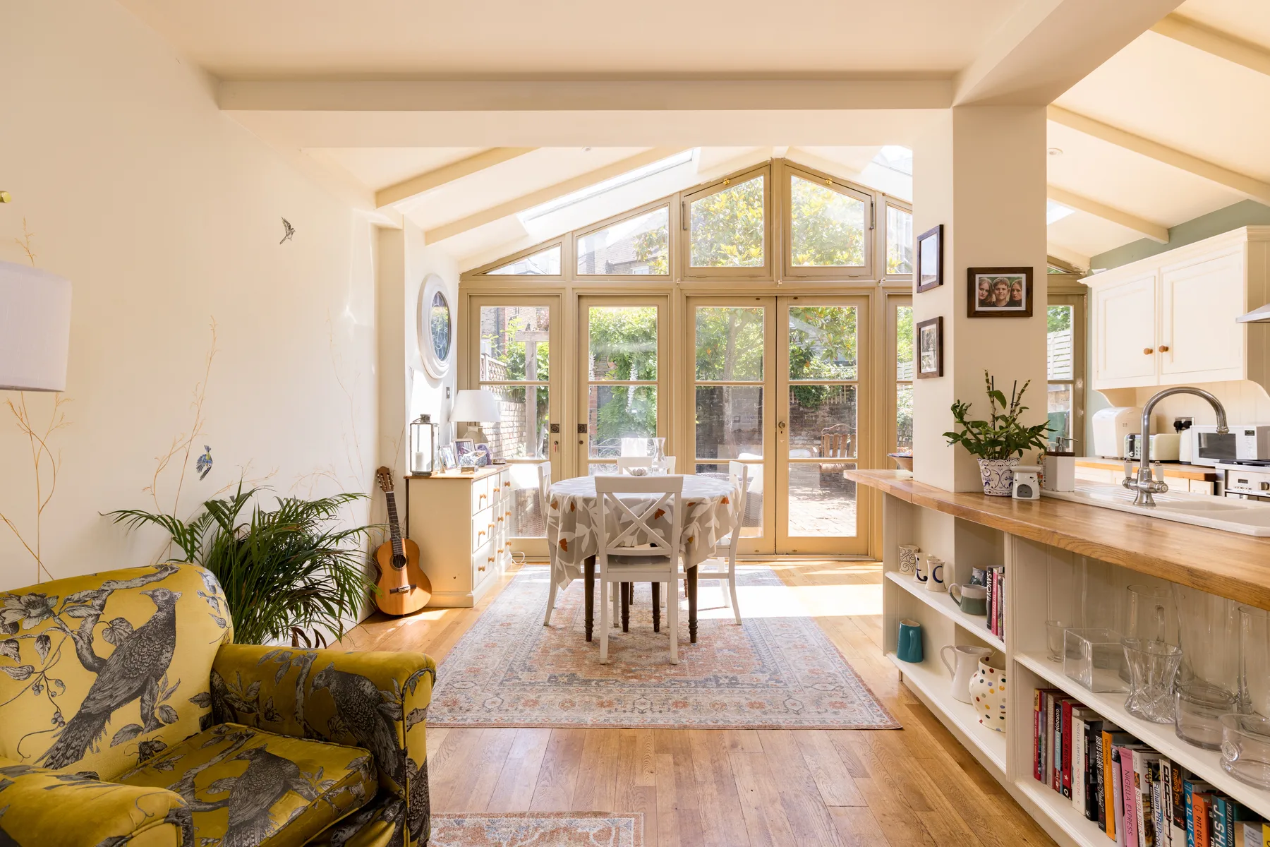 Una luminosa sala-comedor de concepto abierto con grandes ventanas y una isla de cocina.