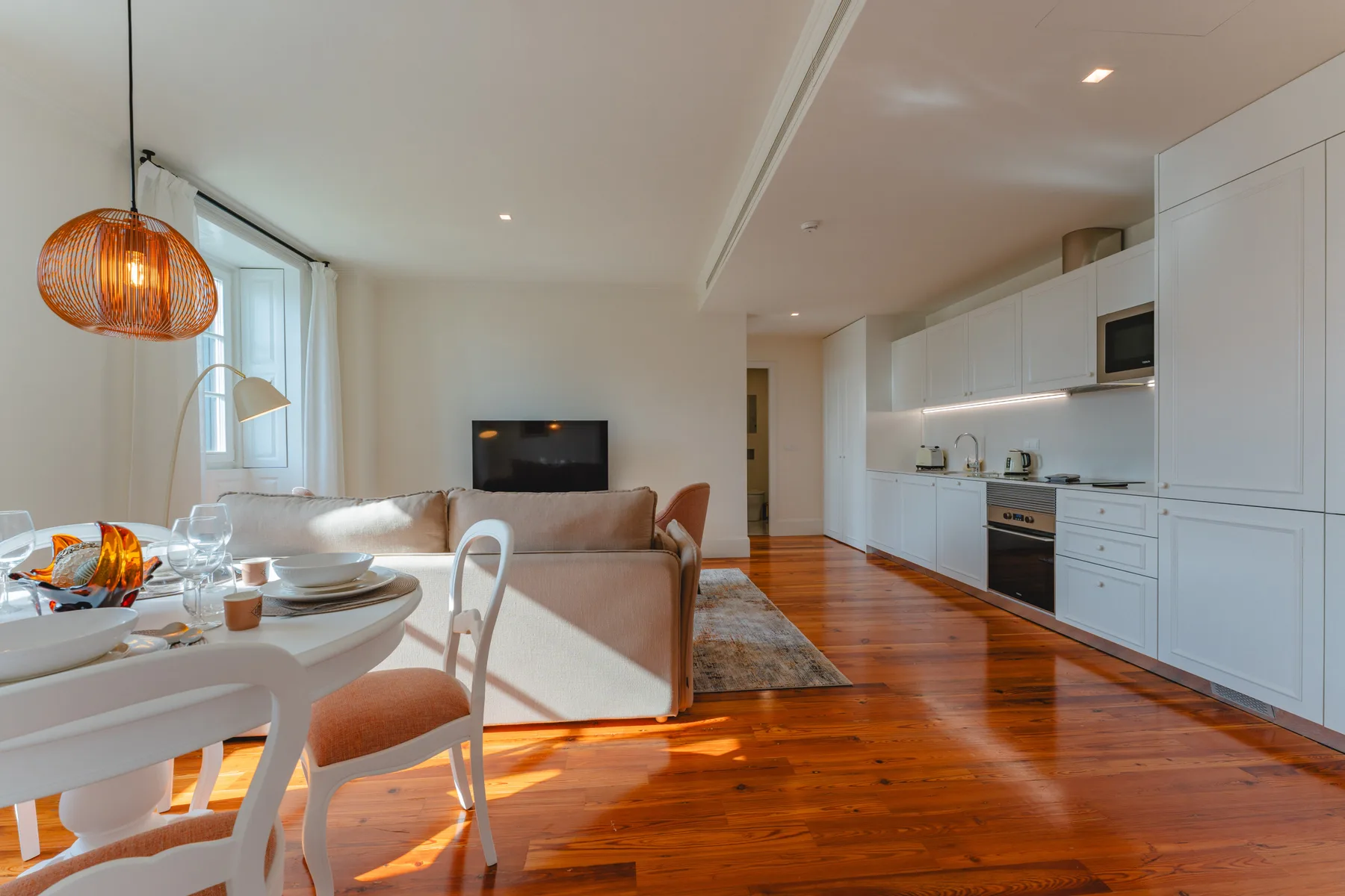 Open-plan living and dining area with a kitchen and television.
