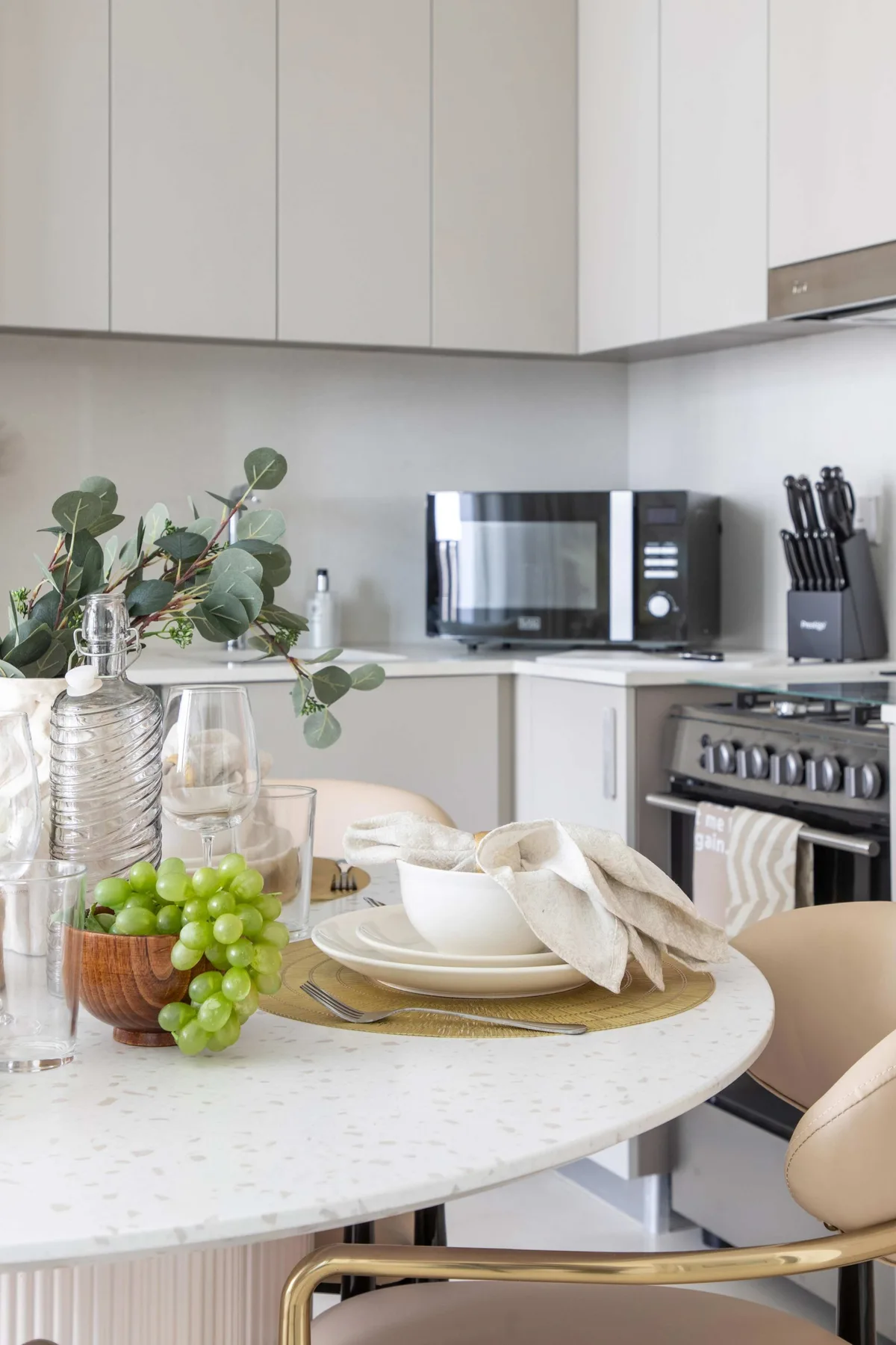 A bright kitchen and dining area with a set table and countertop appliances.