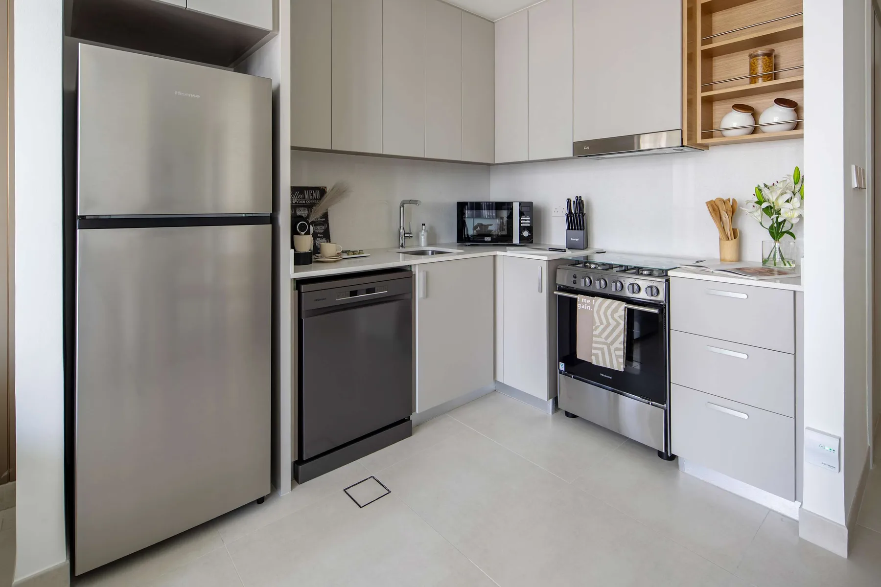 A modern kitchen with light cabinetry and stainless steel appliances.