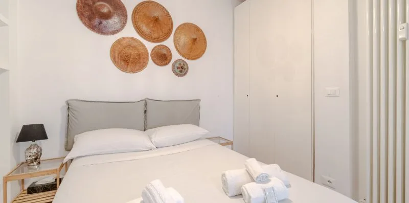 A bedroom with a neatly made bed and round wall decorations.