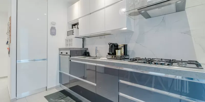 A modern kitchen with white cabinets and a gas cooktop.