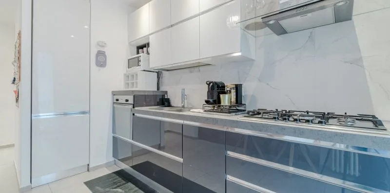 Una cocina moderna con gabinetes brillantes y una estufa de gas.