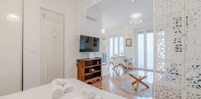 A bright living area with a television, seating, and a small table.