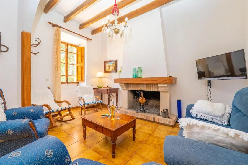 A living room with blue seating, a wooden coffee table, and a fireplace.