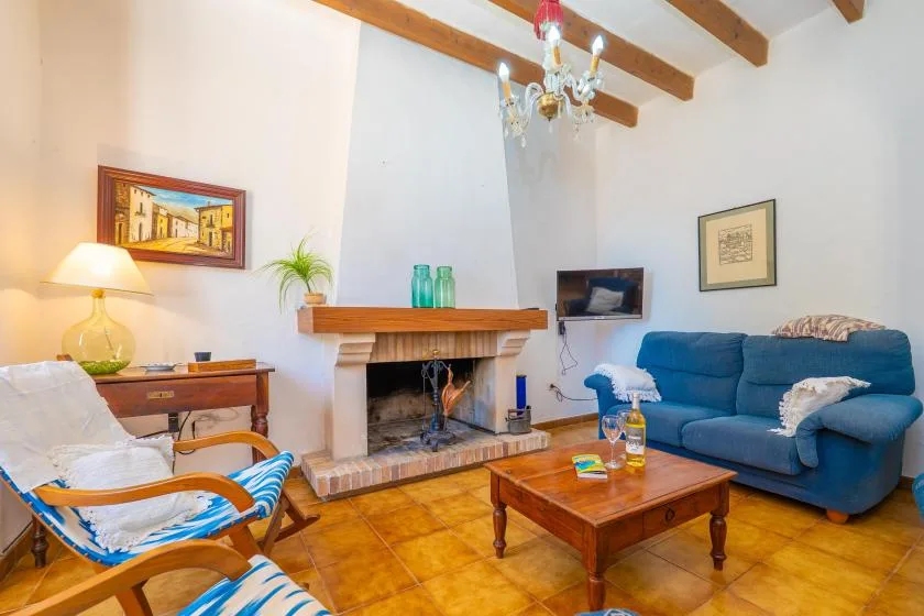 A living room with seating around a fireplace and a wooden coffee table.