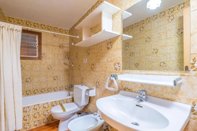 A tiled bathroom with a bathtub, toilet, and sink.
