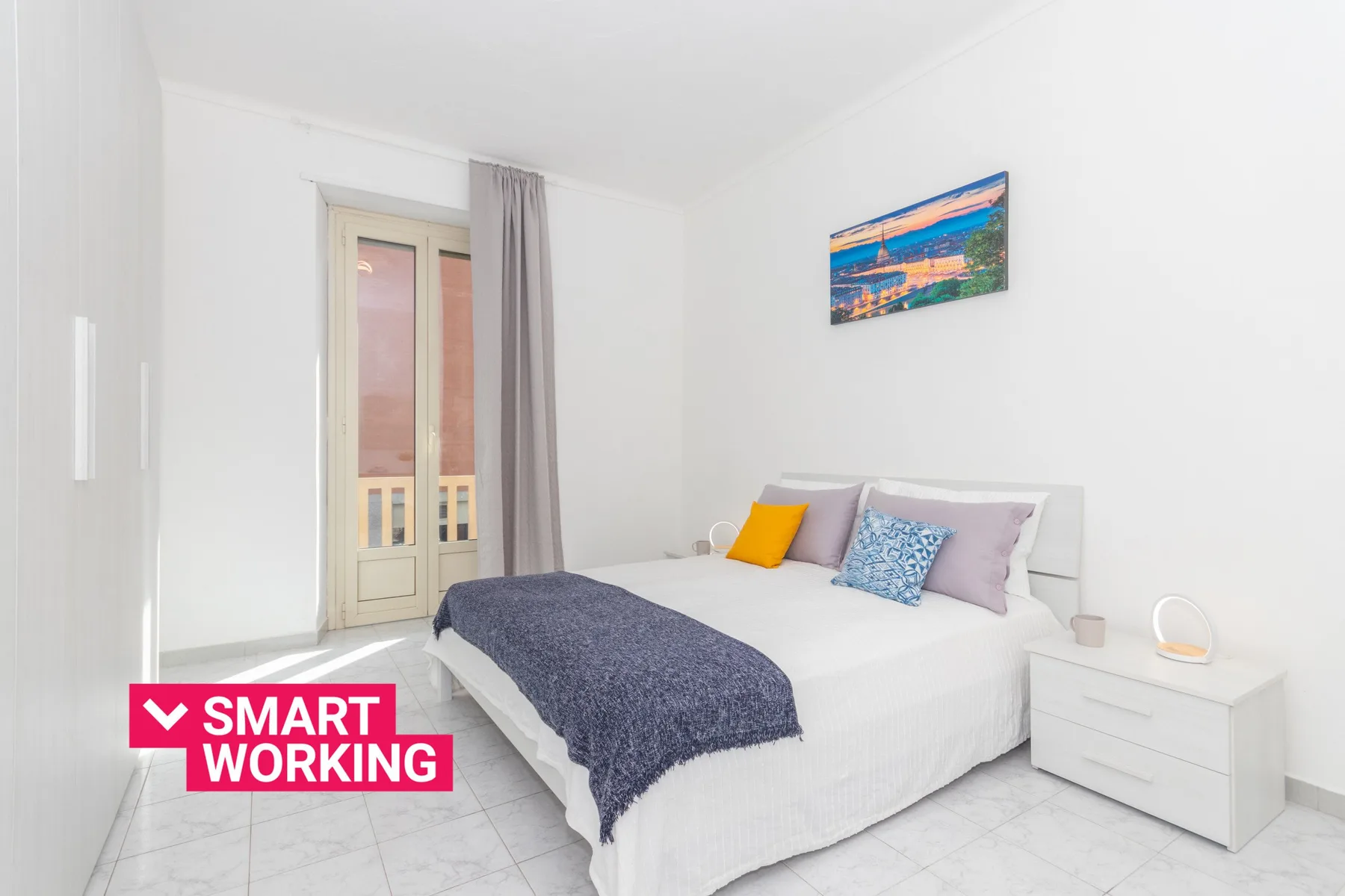 Un dormitorio luminoso con una cama hecha y una ventana al lado.