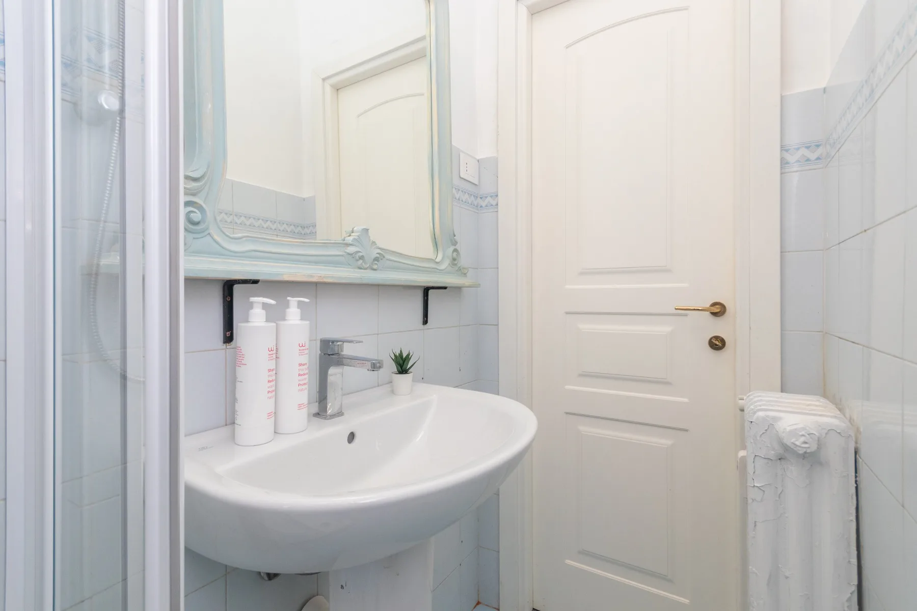 Un baño con lavabo, espejo y ducha.