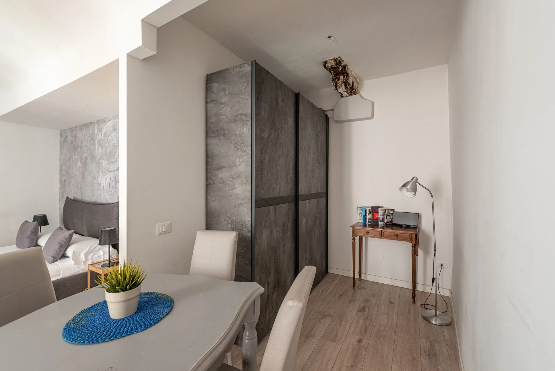A dining area with a table and chairs beside a tall storage cabinet.