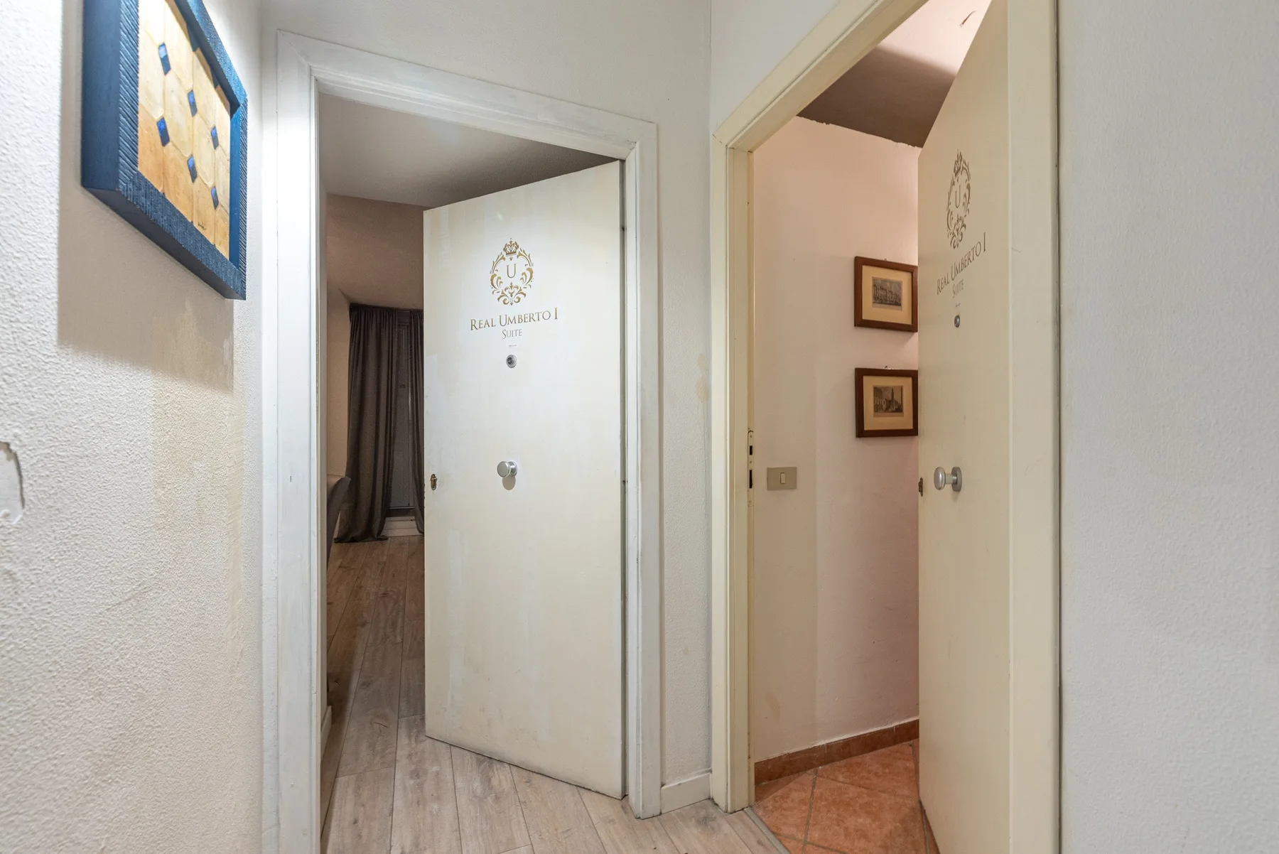 An interior hallway with open doorways and framed wall art.