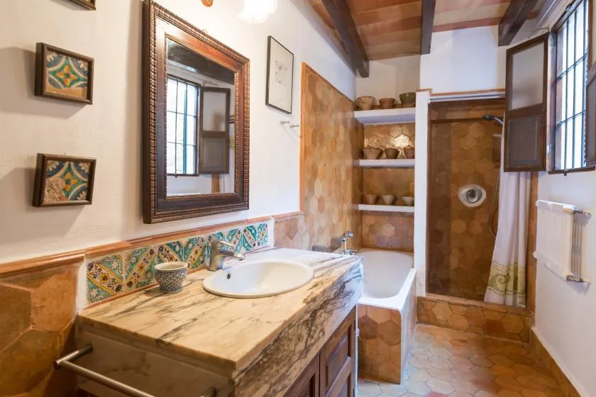 A bathroom with a tiled vanity, bathtub, and walk-in shower.