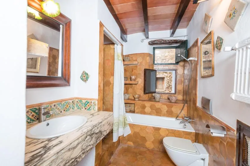 A bathroom with a bathtub, shower, and tiled walls.
