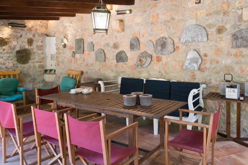 Un comedor rústico con una mesa larga de madera y sillas de colores.