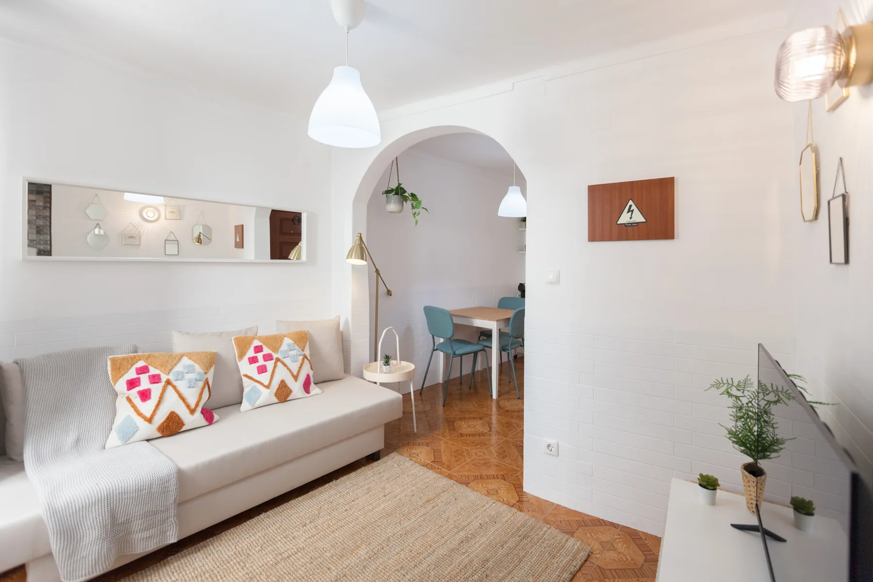 Sala de estar con zona de asientos y comedor visible a través de un arco.