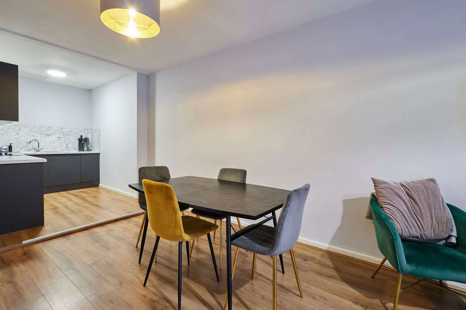 A dining area with a table and chairs beside an open kitchen.