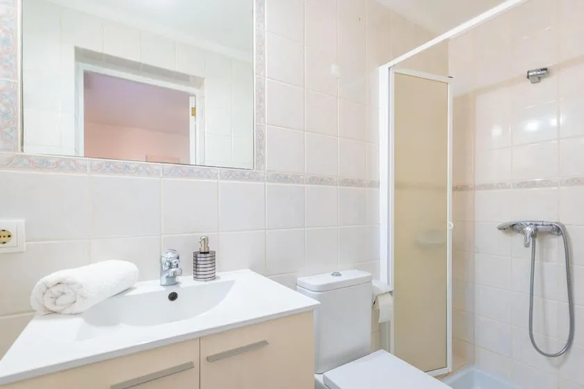 A tiled bathroom with a sink, toilet, and shower.